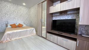 a bedroom with a flat screen tv and a bed at Right Room на Братьев Луканиных in Kaluga