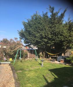 a swing set in a yard with a tree at SherPai Lodge with Heated outdoor Pool Pool open July to October in Kent