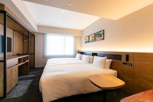 a hotel room with two beds and a table at Hotel Forza Osaka Namba in Osaka
