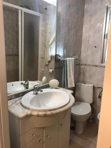 a bathroom with a sink and a toilet at Océano Home in Ayamonte