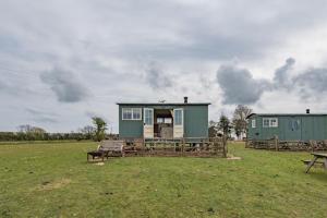 a couple of green buildings in a field at Romney Marsh Huts by Bloom Stays in Ashford