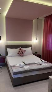une chambre avec un lit avec deux serviettes dessus dans l'établissement HOUSE DILENA TSIMTSIRI Luxury Apartment 2, à Limenaria