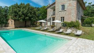 a swimming pool in front of a house at VILLA LA CORTE 6, Emma Villas in Montecastrilli