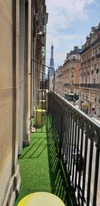 a balcony with green grass and a view of a city at Elysées Union in Paris