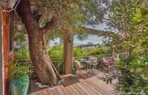 een houten terras met een boom en een tafel en stoelen bij Le Mini Cottage in Bastia