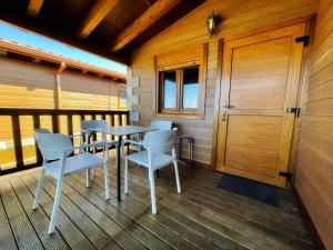a room with tables and chairs on a balcony at Bungalows Cantia in Suances