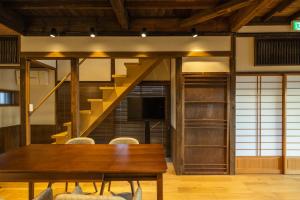 a dining room with a table and a staircase at StellaStoria HAYAMA Seaside house with open-air bath in Hayama