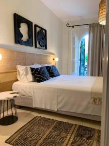 Un dormitorio con una gran cama blanca y una mesa en Villa Marina, en Lefkada