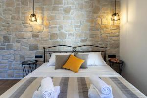 a bedroom with a bed and a stone wall at TEONA Luxury Studio Apartment with jacuzzi and garden view in Sali
