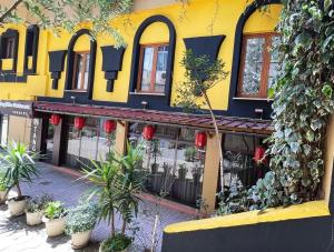 un edificio amarillo con plantas a su lado en La Voglia Hotel Boutique, en Tirana