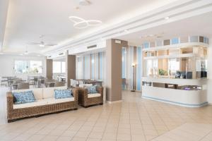 a lobby with two couches and a dining room with a table at Amalfi smart Rooms & Apartments - Ideale per Ragazzi in Riccione