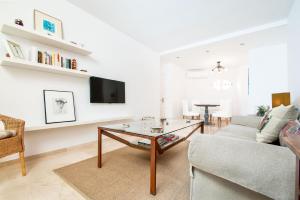 a living room with a couch and a table at Genteel Home Maestranza in Seville