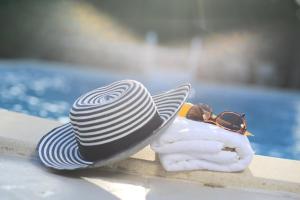 un sombrero blanco y negro y gafas de sol en una toalla en Despina Studios en Agia Marina Nea Kydonias