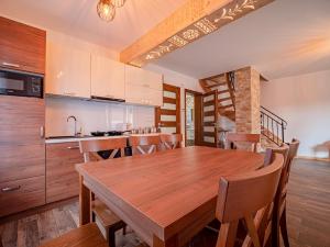 a kitchen and dining room with a wooden table and chairs at Tatrzańska Kryjówka Premium Chalets Zakopane in Poronin