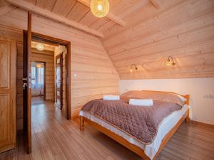ein Schlafzimmer mit einem Bett in einem Holzzimmer in der Unterkunft Tatrzańska Kryjówka Premium Chalets Zakopane in Poronin