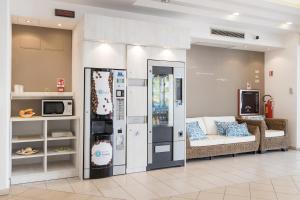 a living room with a couch and a refrigerator at Amalfi smart Rooms & Apartments - Ideale per Ragazzi in Riccione
