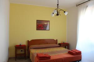 マリーナ・ディ・マンカヴェルサにあるAppartamento Mentaのベッドルーム1室(ベッド1台、シャンデリア付)