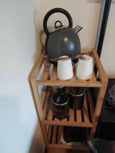 - une bouilloire sur une étagère avec des casseroles et des poêles dans l'établissement Paradise, à Aan de Wolfsberg