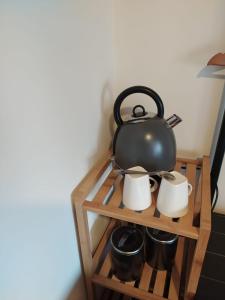 a tea pot on a shelf with mugs at Paradise in Aan de Wolfsberg