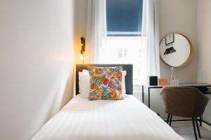 Schlafzimmer mit einem Bett mit einem Kissen und einem Fenster in der Unterkunft CitySpace Borough in London