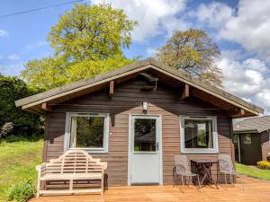 Casa pequeña con puerta blanca, mesa y sillas en Avallon Lodges en Launceston