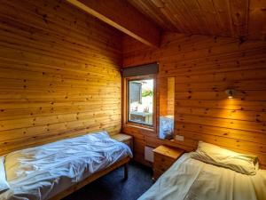 a log cabin with a bed and a window at Avallon Lodges in Launceston