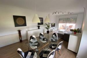 a living room with a glass table and chairs at APARTAMENTO ENTERO CON PISCINA A 5 MIN DEL CENTRO in Figueres