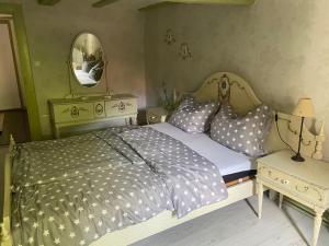 ein Schlafzimmer mit einem Bett mit Kissen und einem Spiegel in der Unterkunft Zeitreise- Haus mit 5 Schlafzimmern in Diemelsee