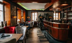 a restaurant with a bar with tables and chairs at Dooscht Gästehaus Reichshof in Kröv