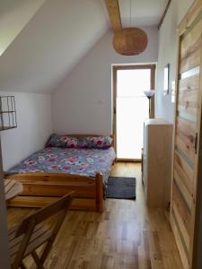 małą sypialnię z łóżkiem i drzwiami w obiekcie Chata Bieszczady w Wetlinie