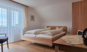 a bedroom with a bed and a table and a window at Hotel Seehalde in Nonnenhorn