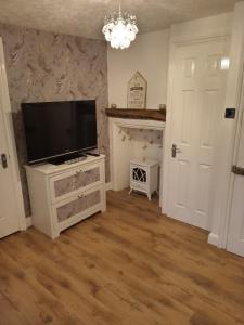 a living room with a flat screen tv on a white cabinet at Havisham Studio Flat Rochester ME1 1XZ in Strood