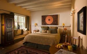 a bedroom with a bed and a table and a window at Las Palomas in Santa Fe