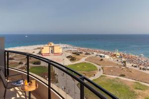 a balcony with a view of a beach and the ocean at Cactus Hotel in Rhodes Town