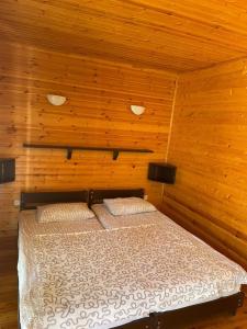 sypialnia z łóżkiem w drewnianym pokoju w obiekcie Hotel Eco Village w mieście Nowy Aton