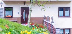 ein Haus mit einer Tür und Blumen davor in der Unterkunft Zelena dolina in Cerkno