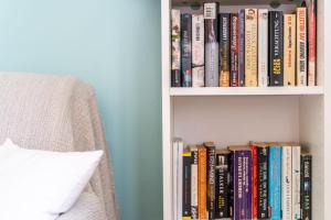 a book shelf filled with books next to a bed at Art Apartment SeaSoul in Zaton