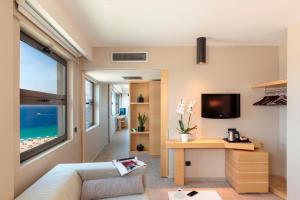 a living room with a couch and a table and a television at Cactus Hotel in Rhodes Town