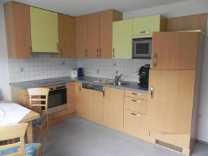 una cucina con armadi in legno e lavandino di Ferienwohnung Schautzgy a Reutte