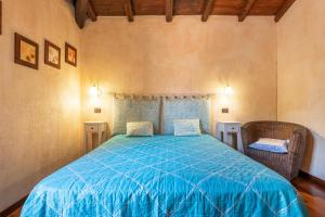 a bedroom with a blue bed and two chairs at Villa Licia San Pietro in Castiadas