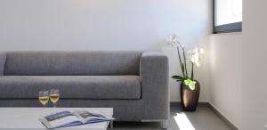 a living room with a couch and two glasses of wine at Cactus Hotel in Rhodes Town