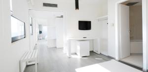 a white room with a bench and a tv on the wall at Cactus Hotel in Rhodes Town