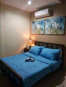 a bedroom with a bed with blue sheets and a fan at Carlo'S Place in Dumaguete