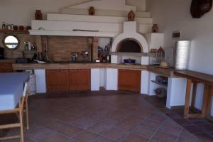 a large kitchen with wooden cabinets and a counter top at The Orange Grove Garden Room in Mytikas