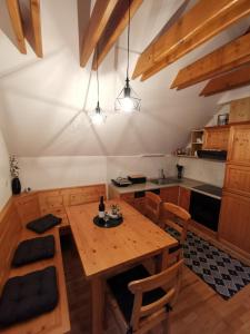 eine Küche mit einem Holztisch und einigen Stühlen in der Unterkunft Apartma Pohorje Bolfenk 5011 in Hočko Pohorje