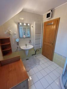 ein Bad mit einem Waschbecken und einem Spiegel in der Unterkunft Apartma Pohorje Bolfenk 5011 in Hočko Pohorje