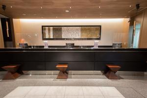 a lobby with a bar with benches in a building at Hearton Hotel Kyoto in Kyoto