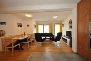 een keuken en een woonkamer met een tafel en stoelen bij Buorcha in Scuol