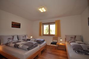 a bedroom with two beds and a window at Buorcha in Scuol