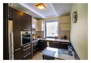 a kitchen with a table and a large window at Apartament Jantarowa in Gdynia